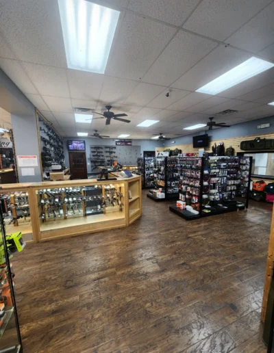 Interior view of a gun shop pro shop featuring floor-to-ceiling merchandise displays and glass counters.